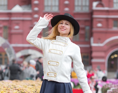 A smiling Chechen girl in front of a red brick building.